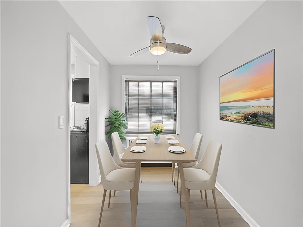 A dining room with a table set for four and a painting on the wall at Huntley Ridge Apartments, Kettering, OH