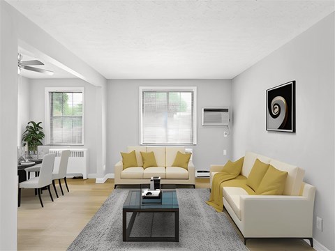 A living room with a white couch and yellow pillows.