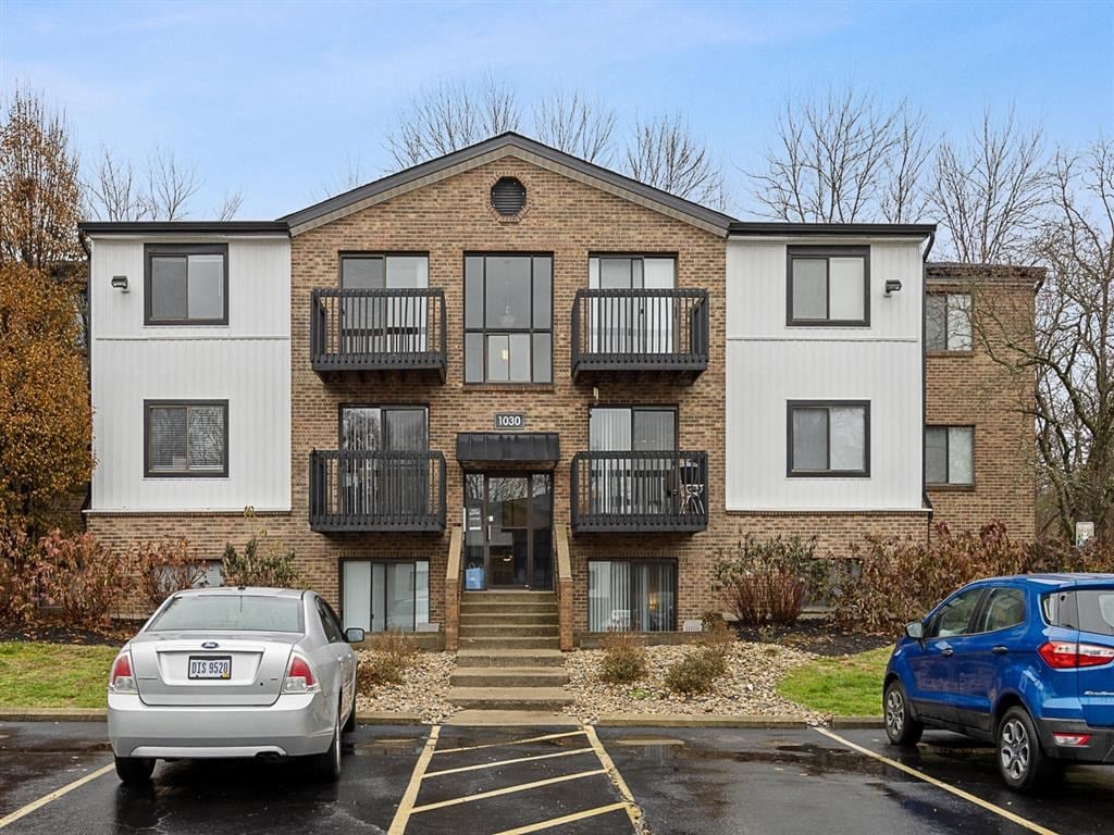 A two-story apartment building with a parking lot in front.