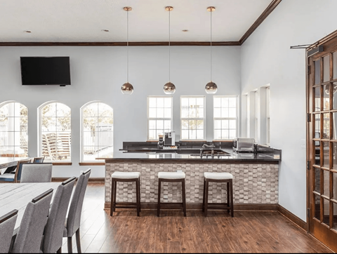 A modern kitchen with a bar area and a dining table.