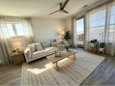 A well-lit living room with a large sofa and a coffee table.