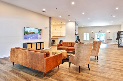 A living room with a brown couch and a television displaying a road.