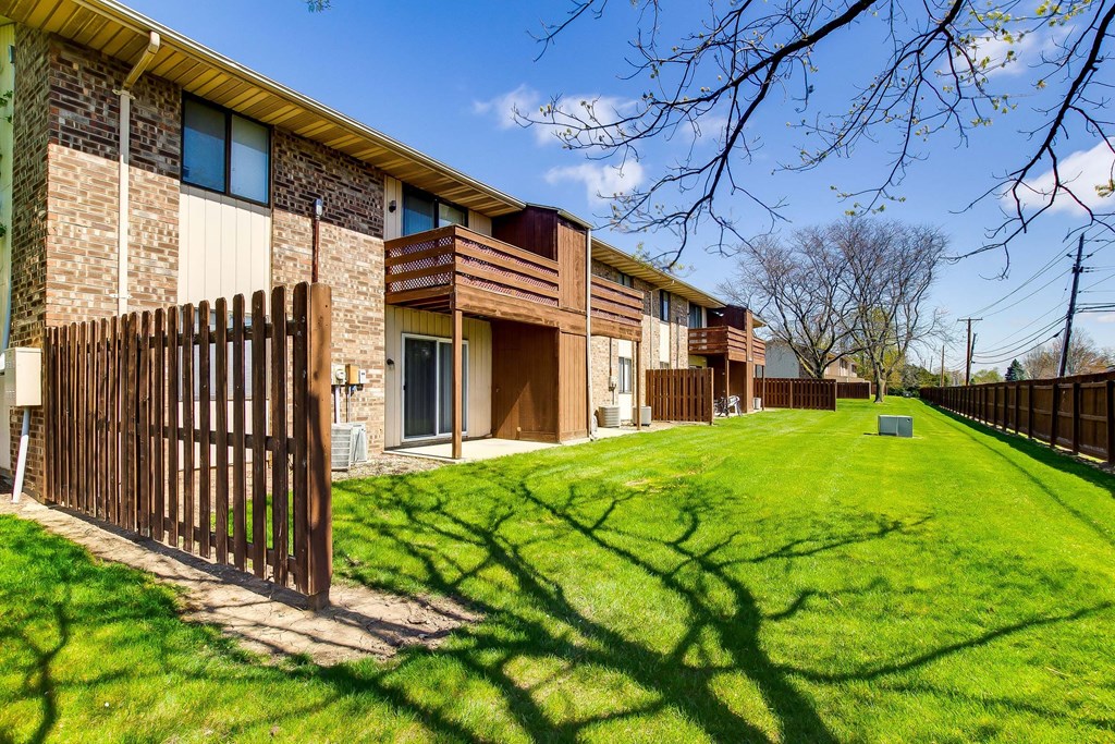 A brown wooden fence in front of a building.