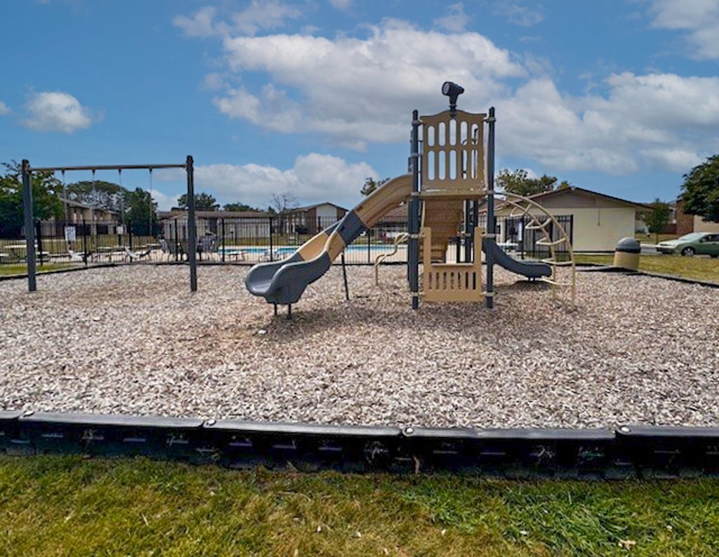 A playground with a slide and a wooden structure.
