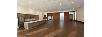A large open space with wooden floors and a kitchen area.
