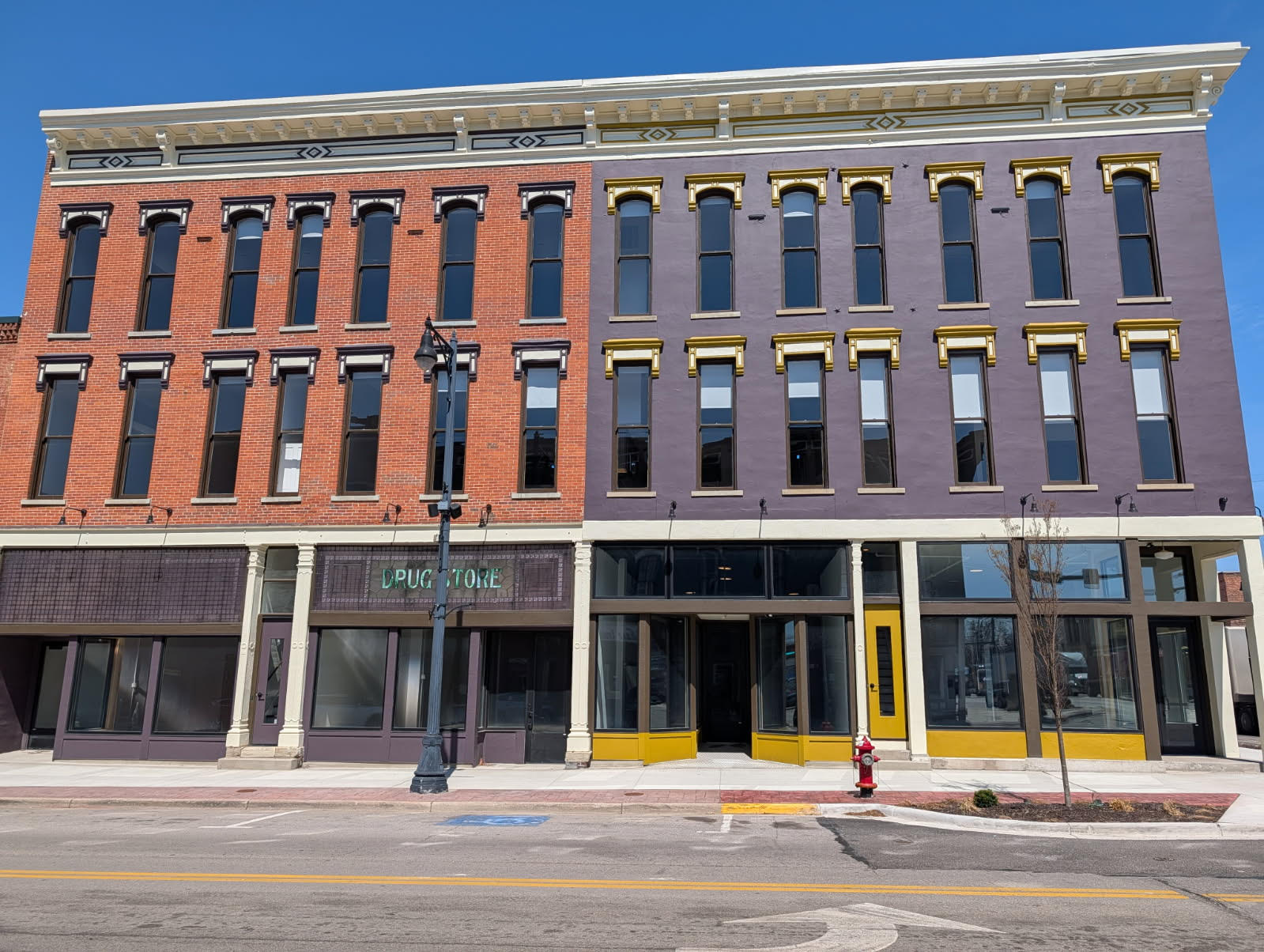 A red and purple building with a yellow fire hydrant in front.