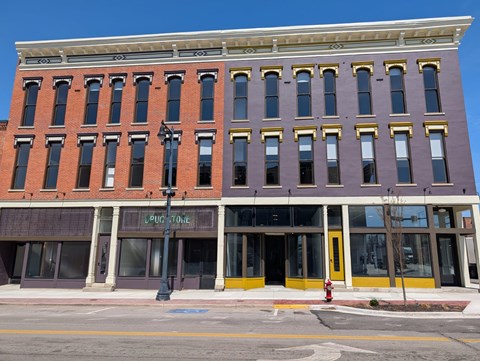A red and purple building with a yellow fire hydrant in front.