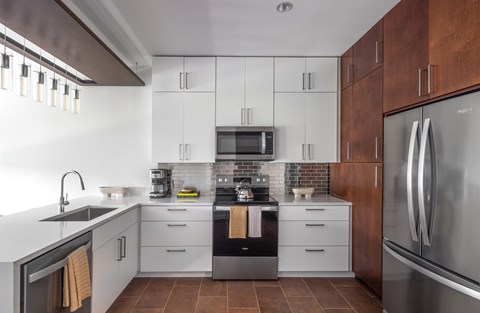 A modern kitchen with white cabinets and a stainless steel refrigerator.