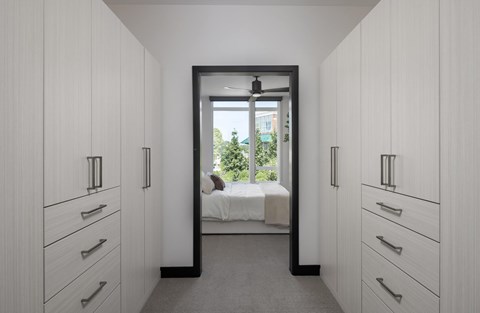 A white bedroom with a bed and a window.