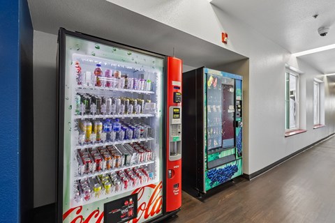 A Coca-Cola vending machine is in a hallway.