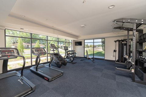 A spacious fitness center with treadmills, elliptical machines, and other exercise equipment.