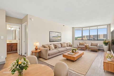 A living room with a brown sofa, a wooden coffee table, and a painting on the wall.