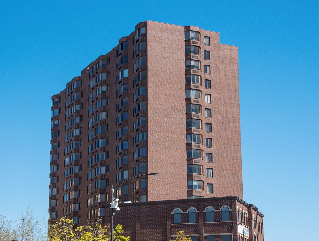 a tall brick apartment building against a blue sky