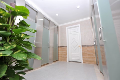 A white door is in a hallway with a plant on the left.