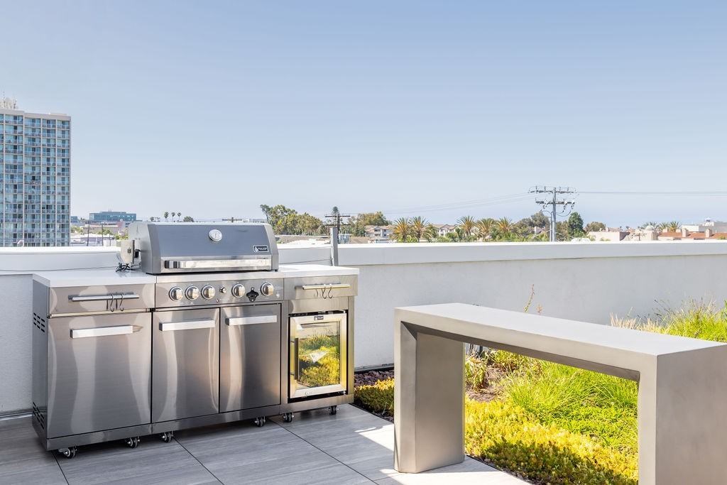 A stainless steel outdoor kitchen set up on a balcony.