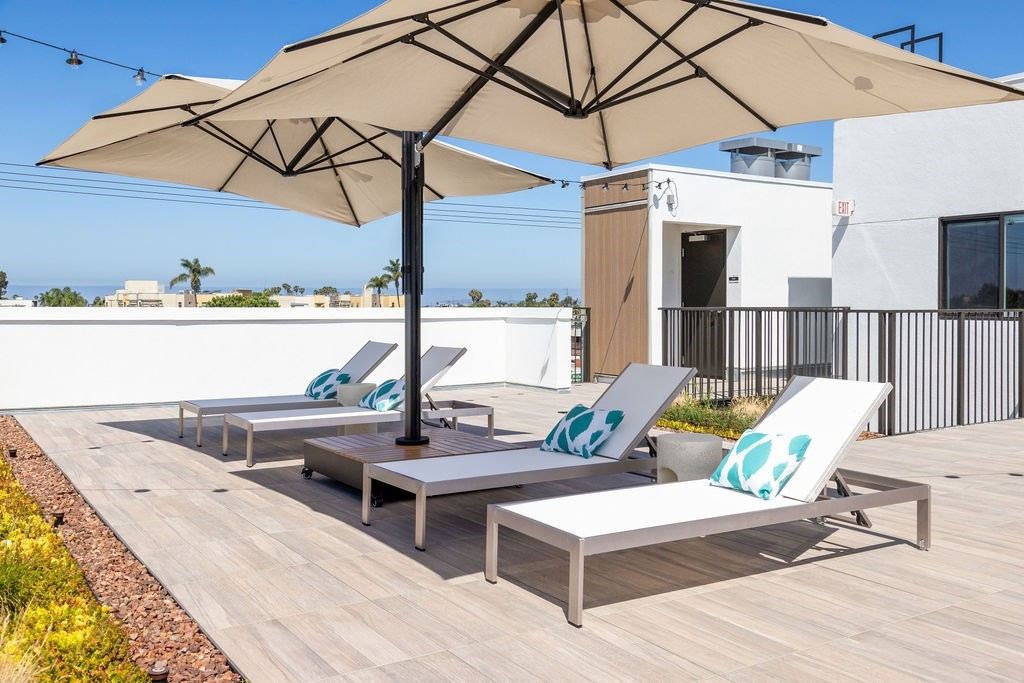 A patio with a table and chairs under an umbrella.