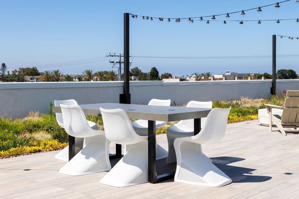 A white table and chairs are set up on a wooden deck.