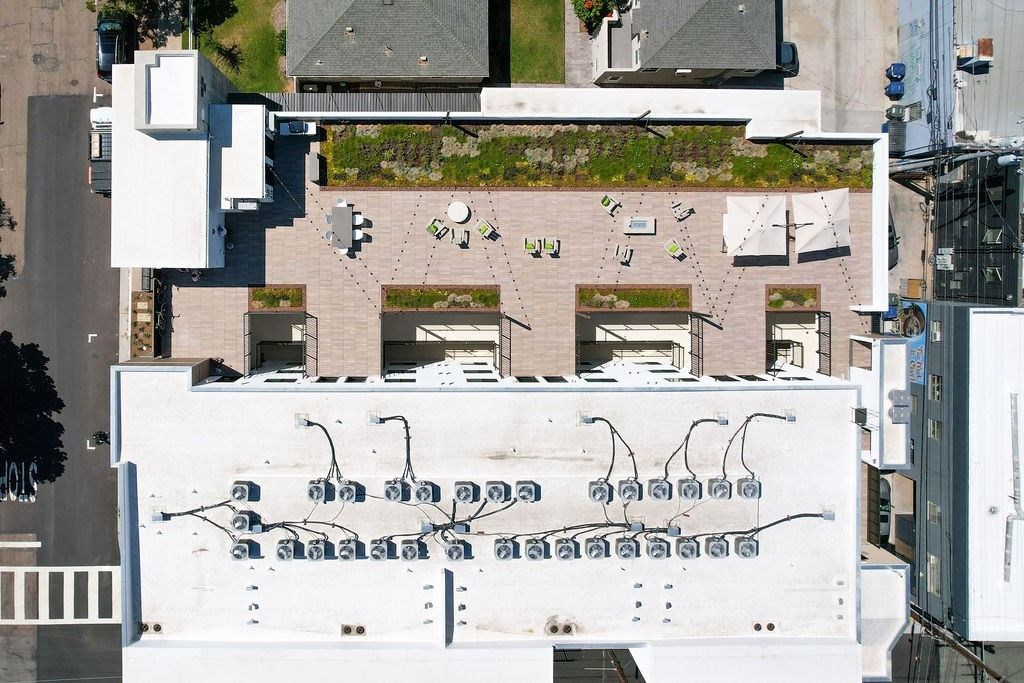 A white building with a lot of windows and a green roof.