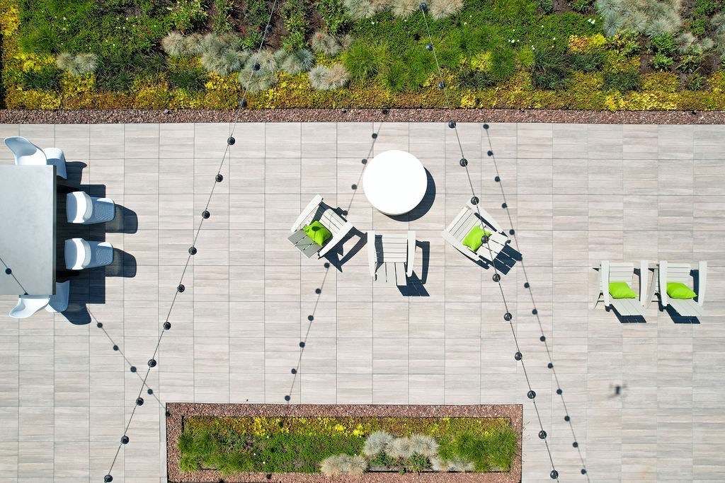 A patio with a table, chairs, and a lamp post.