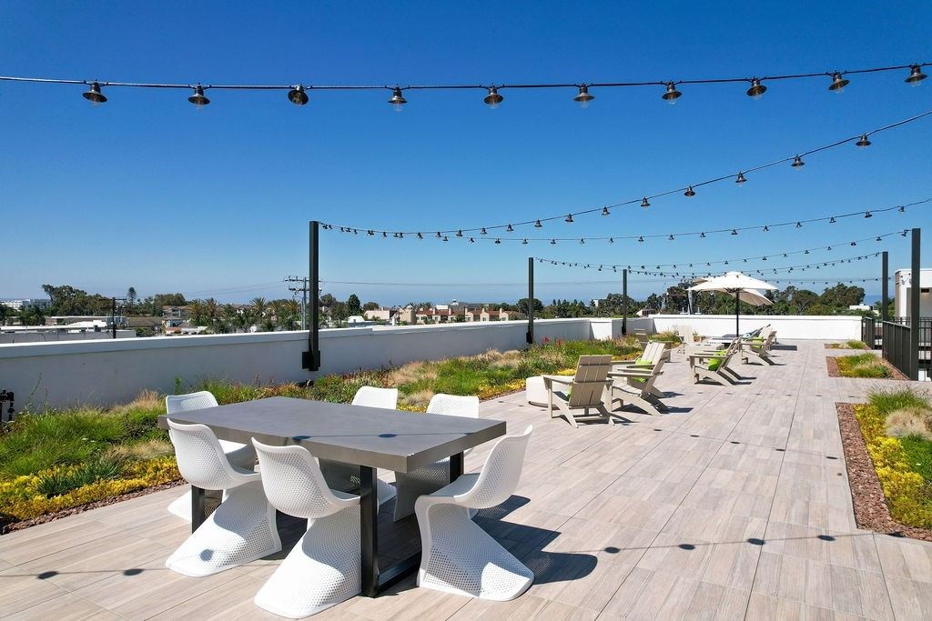 A patio with a table and chairs is decorated with string lights.