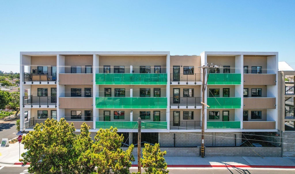 A modern building with balconies and a green awning.