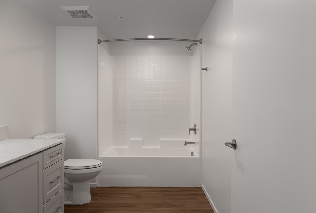 A white bathroom with a toilet, sink, and bathtub.