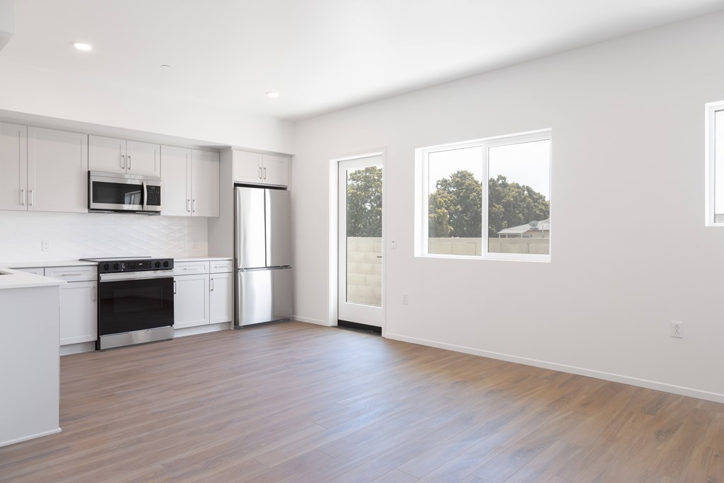 A modern kitchen with white cabinets and stainless steel appliances.