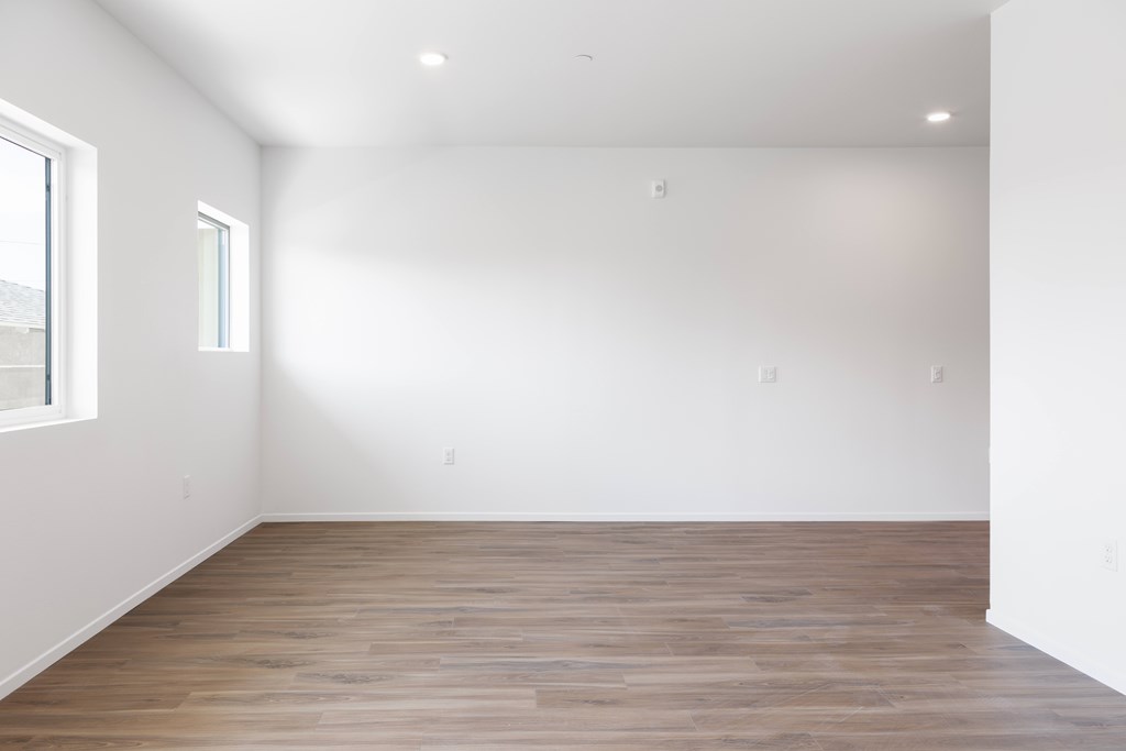 A room with wooden flooring and white walls.