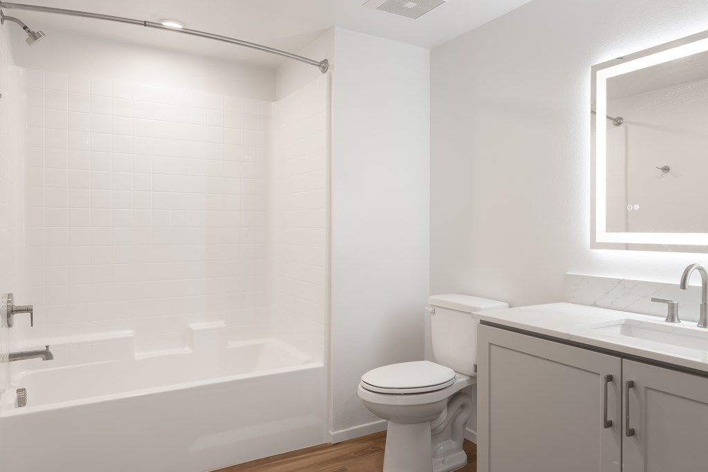 A white bathroom with a toilet, sink, and bathtub.