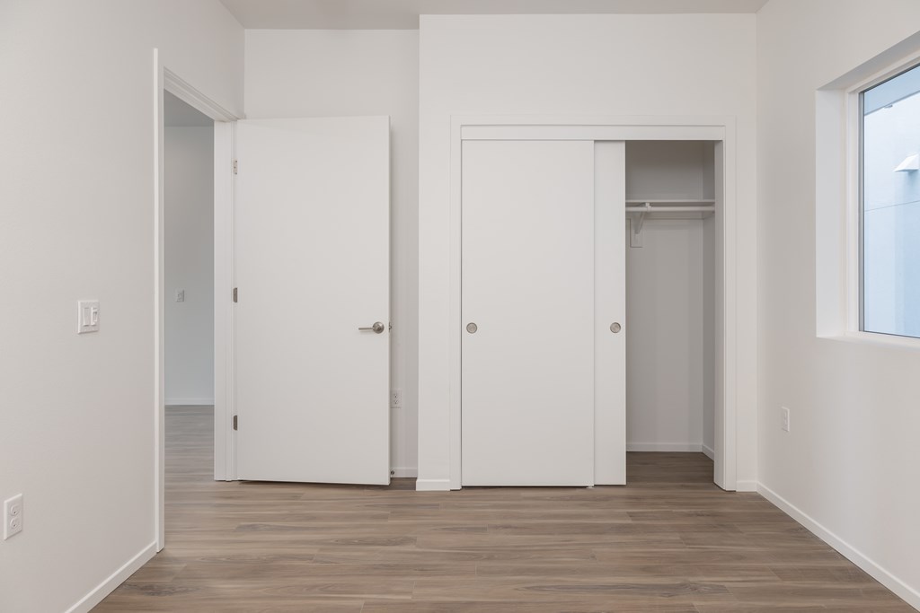 A room with two white doors and a window.