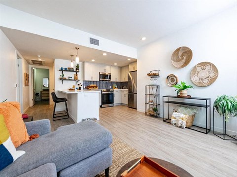 A living room with a grey couch and a wooden coffee table.