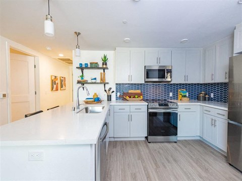 A kitchen with white cabinets and a white countertop.