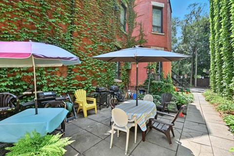 A patio with a table and chairs under umbrellas.