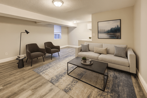 A living room with a couch, chairs, and a coffee table.