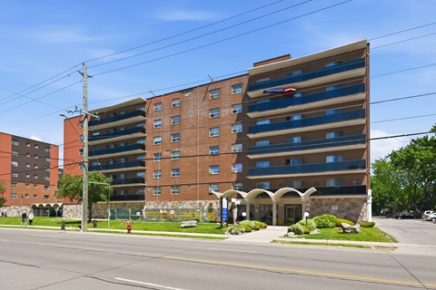 A large brick building with a parking garage on the top floor.