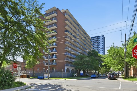 A tall apartment building with a stop sign in front of it.