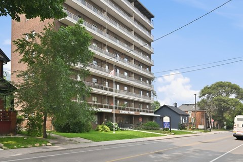 A tall apartment building with a bus parked in front of it.
