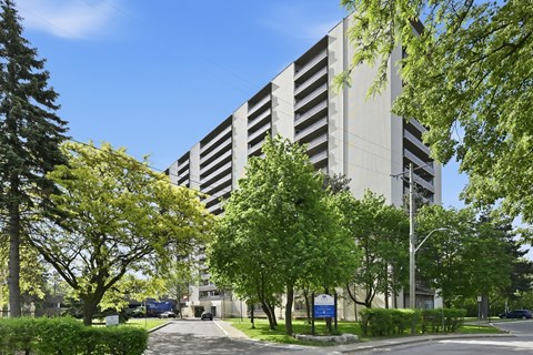 A large grey building with a blue sign in front of it.
