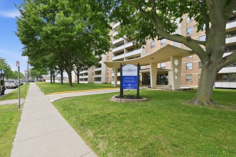 A sign in front of a building that says Pleasant.