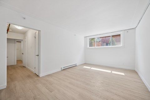 A room with a window and a door leading to another room.
