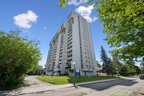 A tall white building with a green lawn in front.
