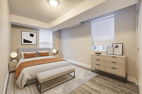 A bedroom with a bed, nightstand, and dresser.
