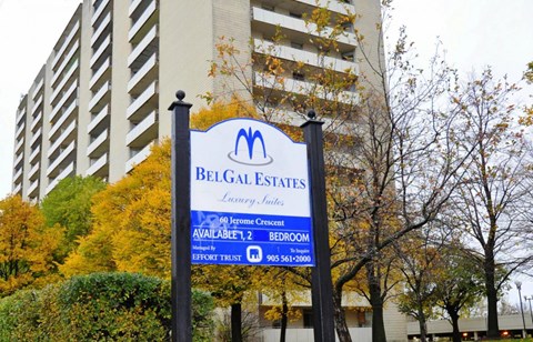 A sign for Belgal Estates is displayed in front of a building.