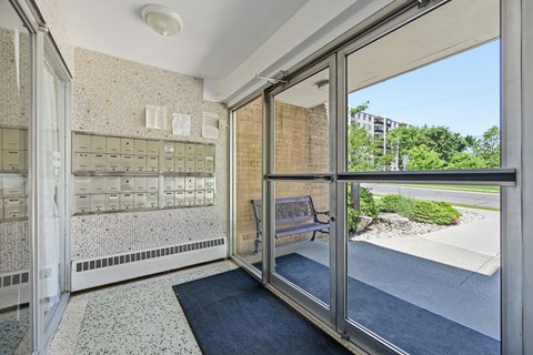 A view of a hallway with a bench and a window.