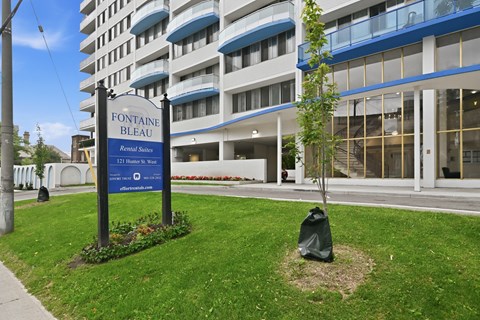 A sign for Fontaine Bleau Residences stands in front of a building.