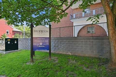 A sign for Brockton is in front of a brick building.
