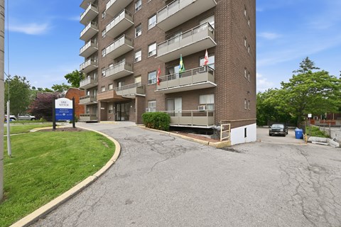 A tall apartment building with a Canadian flag on the balcony.