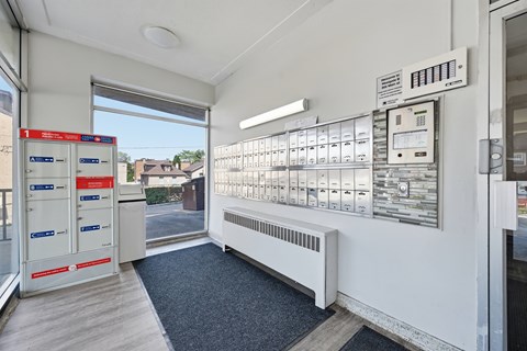 A row of mailboxes are lined up on a wall.