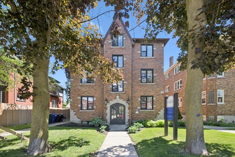 A large brick building with a gate in front.