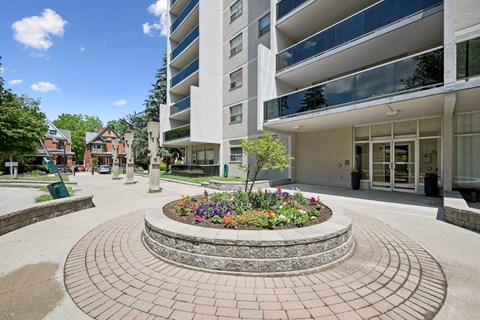 A large building with a circular flower bed in front.